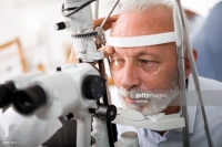 Un homme en train de faire le test de la vue par un optométriste