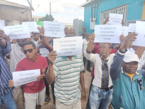 Les chauffeurs de taxi bradissent des pancartes pour faire valoir leurs mécontentements envers la décision communale.